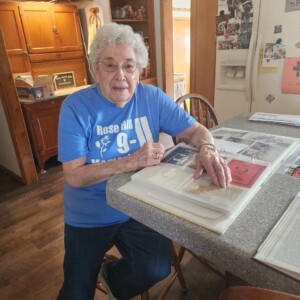 Linot displays her cherished book of Rose Hill, showcasing a rich collection of memories, articles, and artifacts.